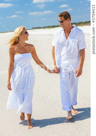 Happy Man Woman Couple Holding Hands Walk on Beach Happy Man Woman Couple Holding Hands Walk on Beach 43784415