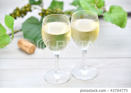 注意)背景中的葡萄葉是人造花。清爽的葡萄酒,白葡萄酒,酒杯表圖像。 注意)背景中的葡萄葉是人造花。清爽的葡萄酒,白葡萄酒,酒杯表圖像。 43784775