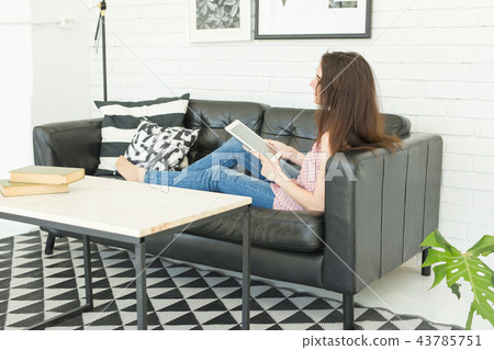 People, working and technology concept - relaxed young woman sitting on sofa with tablet People, working and technology concept - relaxed young woman sitting on sofa with tablet 43785751
