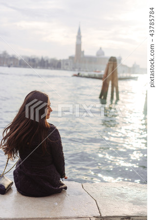 Girl sitting on the edge of the Grand Canal Girl sitting on the edge of the Grand Canal 43785784