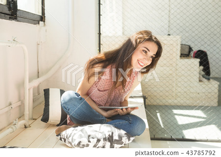 People, technology and interior concept - happy young woman sitting on the floor with tablet People, technology and interior concept - happy young woman sitting on the floor with tablet 43785792
