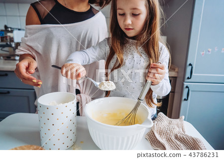 mom teaches her little daughter to cook food 43786231