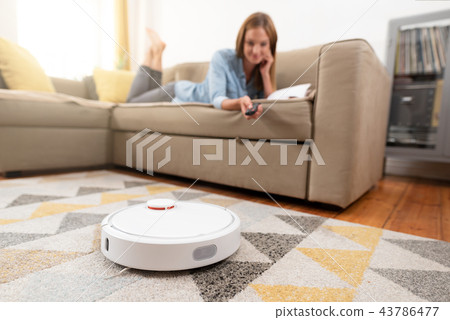 Robotic vacuum cleaner cleaning the room 43786477