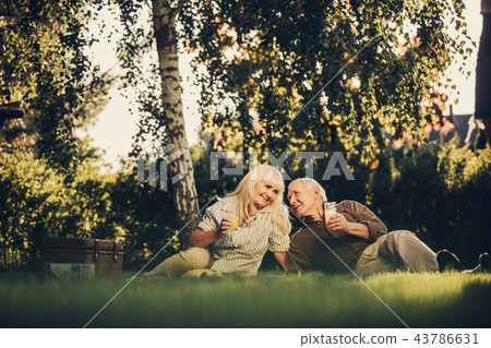 Happy glancing mature twosome spending time outdoors Happy glancing mature twosome spending time outdoors 43786631