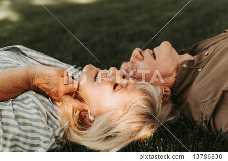 Joyous smiling elderly couple listening to music Joyous smiling elderly couple listening to music 43786830