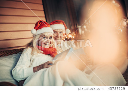Cheerful old couple celebrating Christmas time together 43787229