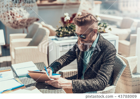 Calm male making notes in notebook outside Calm male making notes in notebook outside 43788009