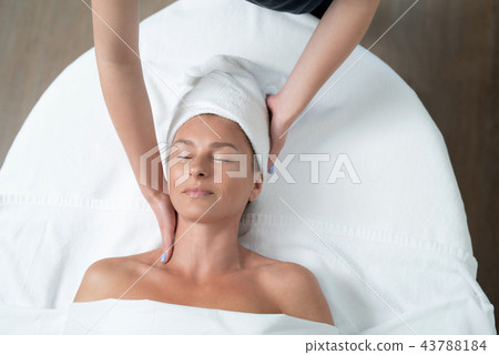 Smiling middle aged lady enjoying neck massage at spa salon 43788184
