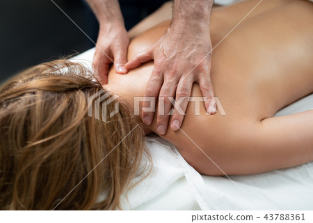 Professional masseur doing relaxing massage on lady back Professional masseur doing relaxing massage on lady back 43788361