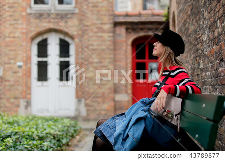 Young girl in hat sitting at bench in Bruges 43789877