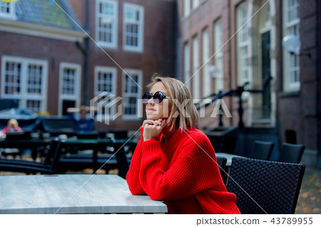 girl in red sweater and sunglasses in Amsterdam cafe girl in red sweater and sunglasses in Amsterdam cafe 43789955