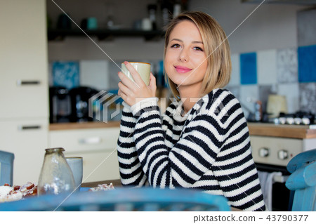 Young girl with cup and cake at kitchen Young girl with cup and cake at kitchen 43790377