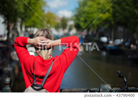 girl in red sweater and backpack at bridge in Amsterdam girl in red sweater and backpack at bridge in Amsterdam 43790400