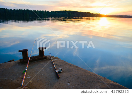 fishing rods lie on the dock next to the river 43792225