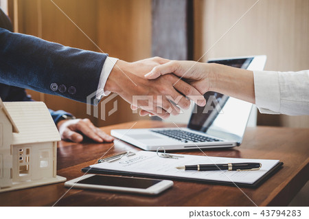 Real estate agent and customers shaking hands together celebrati Real estate agent and customers shaking hands together celebrati 43794283