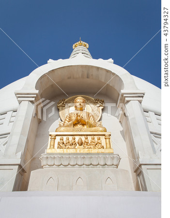 Gilded bas-relief of Buddha in a dharmachakra Gilded bas-relief of Buddha in a dharmachakra 43794327