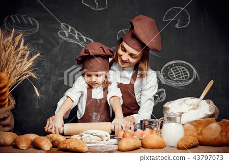 Woman and girl making pastries together 43797073