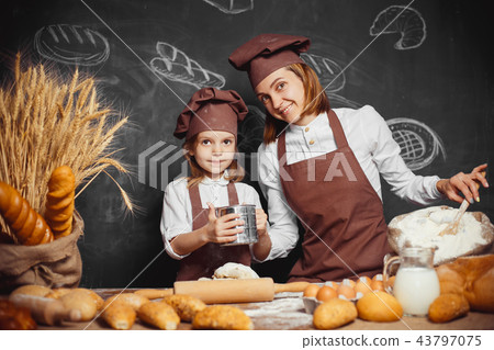 Woman and girl making pastries together 43797075