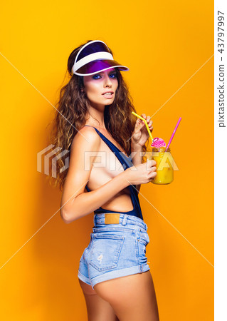 Sexy Woman in white swimsuit and blue jeans shorts, trendy visor holding beverage Sexy Woman in white swimsuit and blue jeans shorts, trendy visor holding beverage 43797997
