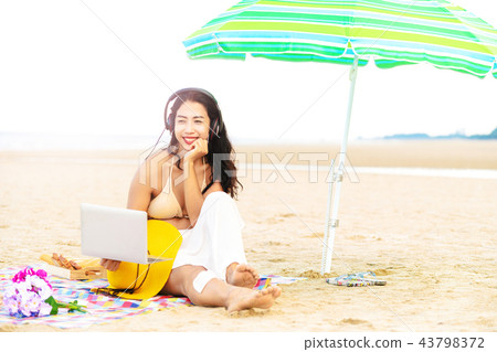 Plus size young woman sitting on the beach. 43798372