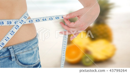 Composite image of midsection of woman measuring waist 43799264