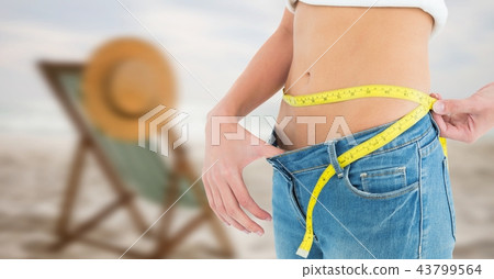 Composite image of midsection of woman measuring waist 43799564