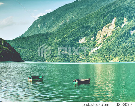 Boat on  green blue water level of Alps lake 43800059