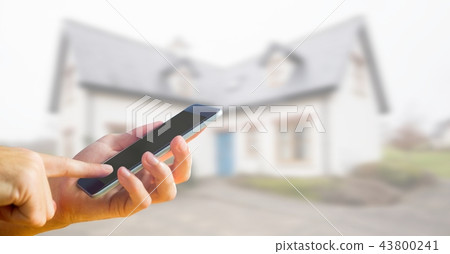 phone in hand with house background 43800241