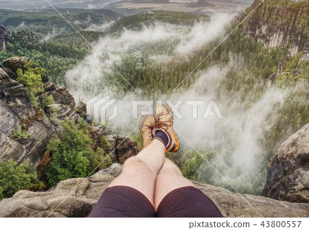 View over male naked legs into misty valley View over male naked legs into misty valley 43800557