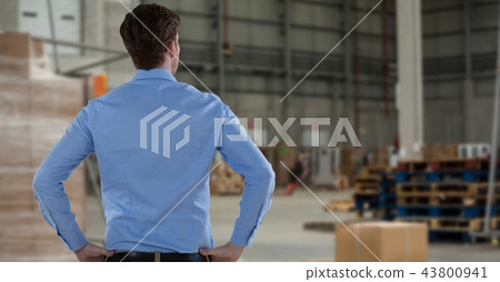Businessman holding hands on hips in warehouse Businessman holding hands on hips in warehouse 43800941
