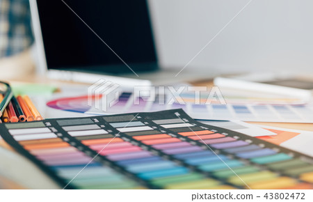 Designer's equipment is placed on the desk. 43802472