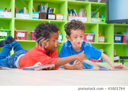Two boy kid lay down on floor and reading tale 43805764