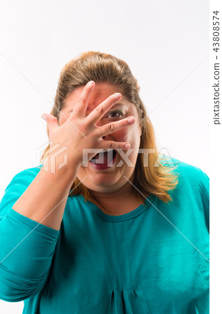 Scared woman peeking from fingers over the face 43808574