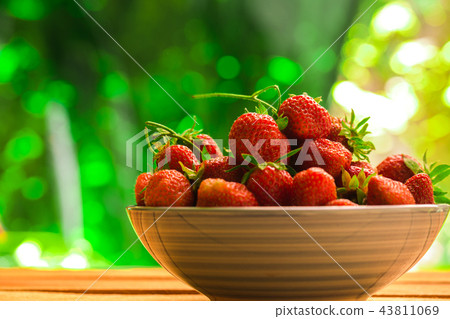 fresh strawberries in a blue plate on background 43811069