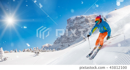 Skier skiing downhill in high mountains Skier skiing downhill in high mountains 43812100