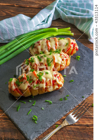 Hasselback potato with chorizo sausage and cheese Hasselback potato with chorizo sausage and cheese 43813114