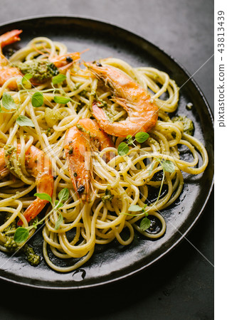 Spaghetti with pesto and prawns served on plate 43813439