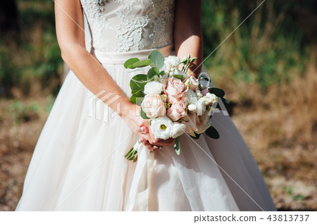 closeup of bride hands holding beautiful wedding bouquet 43813737