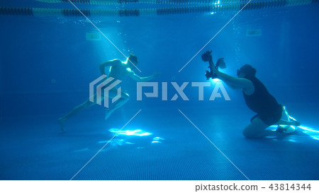 Underwater photography. A male model is posing underwater. A young handsome man is running along the 43814344