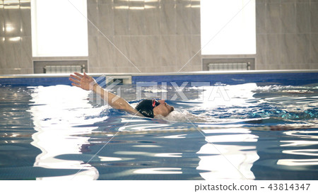 Beautiful professional swimmer swiming backstroke in the pool, camera dolly shot Beautiful professional swimmer swiming backstroke in the pool, camera dolly shot 43814347