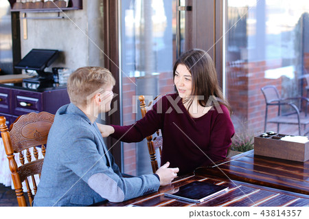 Couple sitting near table with smartphone and laptop, girlfriend Couple sitting near table with smartphone and laptop, girlfriend 43814357