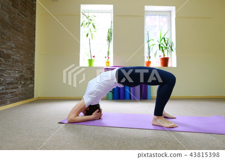 Young beautiful woman sitting on floor on mat for fitness and pe 43815398