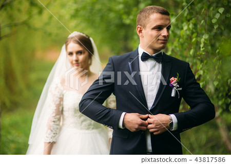 The newlyweds are walking in the park on the wedding day. The bride and groom Enjoying at the 43817586