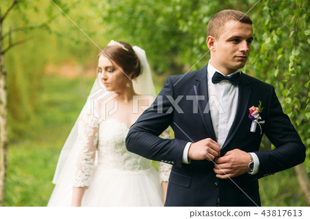 The newlyweds are walking in the park on the wedding day. The bride and groom Enjoying at the 43817613