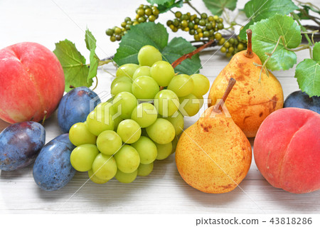 The leaves in the background are artificial flowers. Image of high-class autumn fruit. White peach, Shine muscat (mochi), pear, plum. 43818286