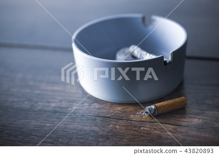 ashtray with cigarette on wood table. ashtray with cigarette on wood table. 43820893