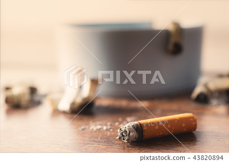 ashtray with cigarette on wood table. ashtray with cigarette on wood table. 43820894