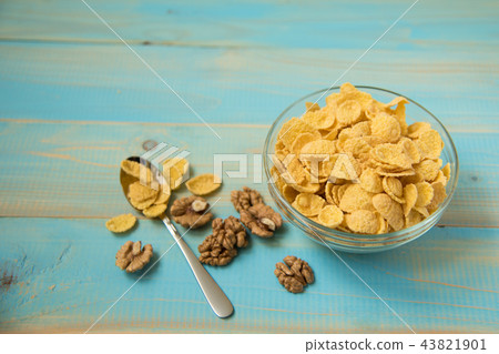 Tasty cornflakes with walnut in glass bowl Tasty cornflakes with walnut in glass bowl 43821901