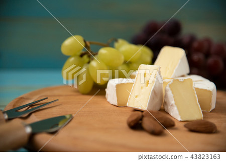 cheese camembert with raspberries and nuts, melange on a blue background cheese camembert with raspberries and nuts, melange on a blue background 43823163