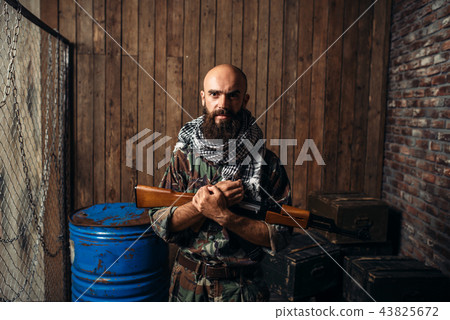 Terrorist in uniform holds kalashnikov rifle 43825672